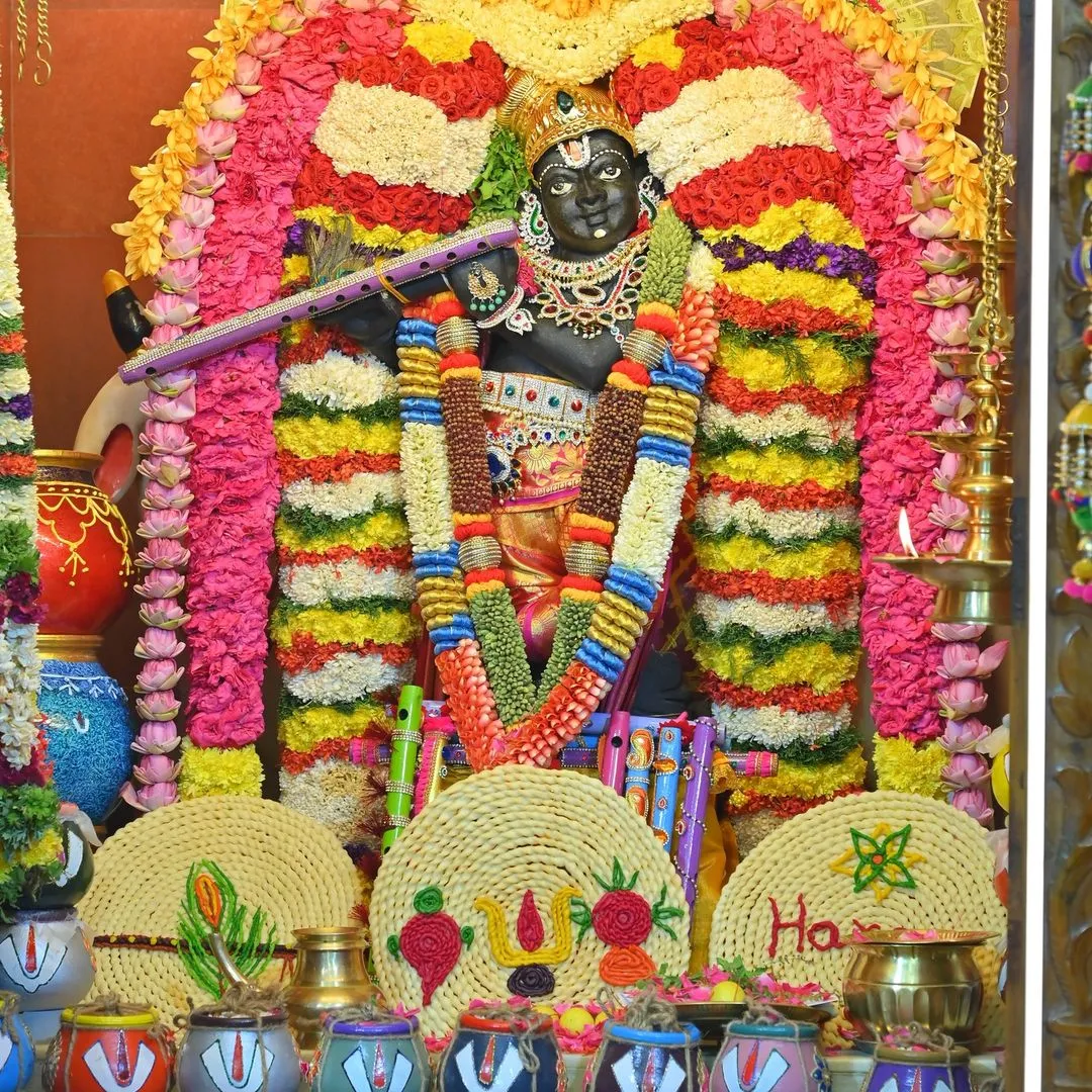 Image 1 - Main deity at Etteluthuperumal Temple adorned with colorful flower garlands