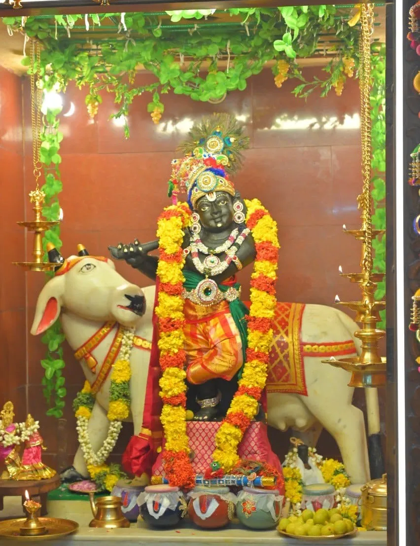 Image 5 - Deity at Etteluthuperumal Temple with cow, adorned with marigolds
